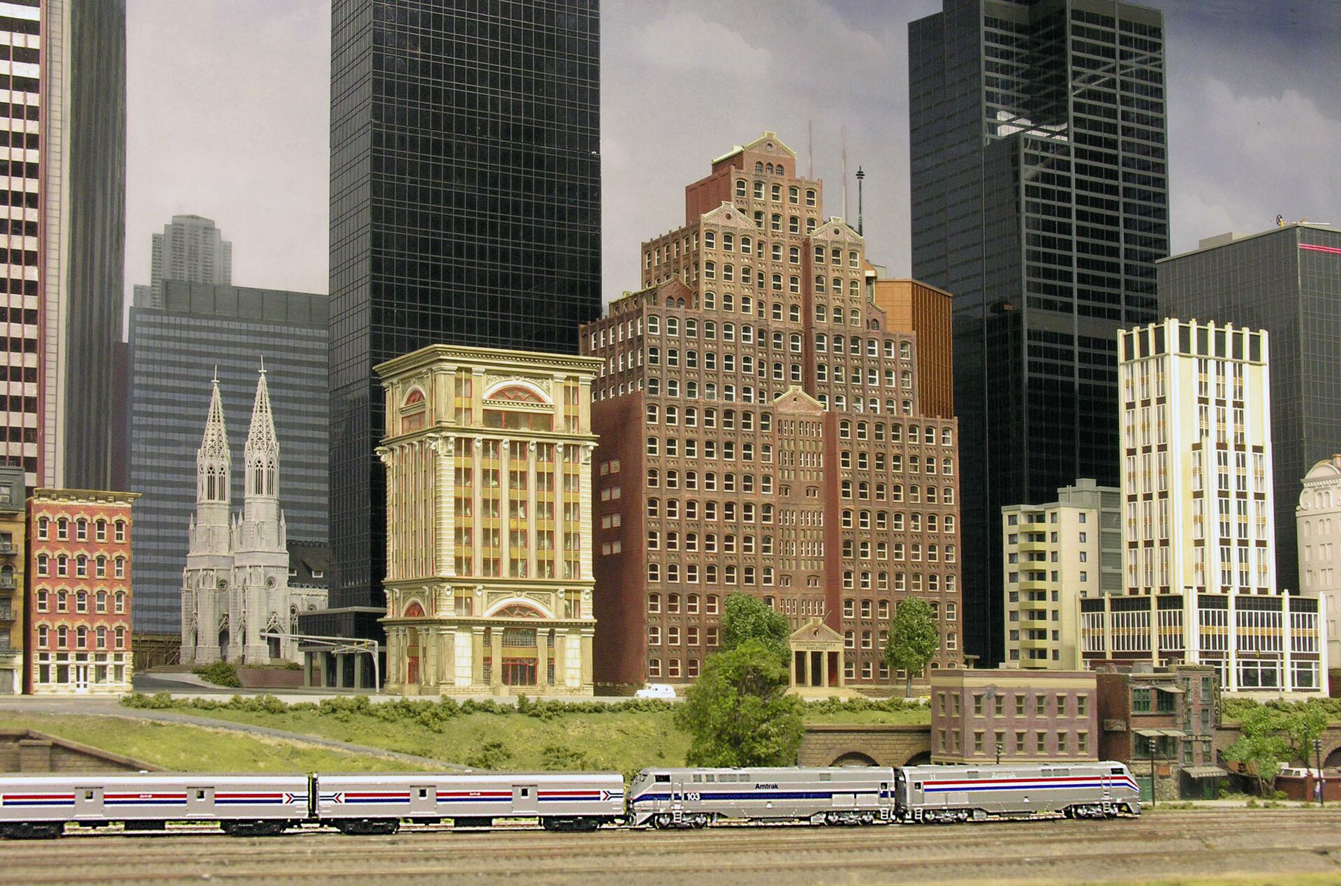 Silberner Reisezug vor der Skyline der Stadt